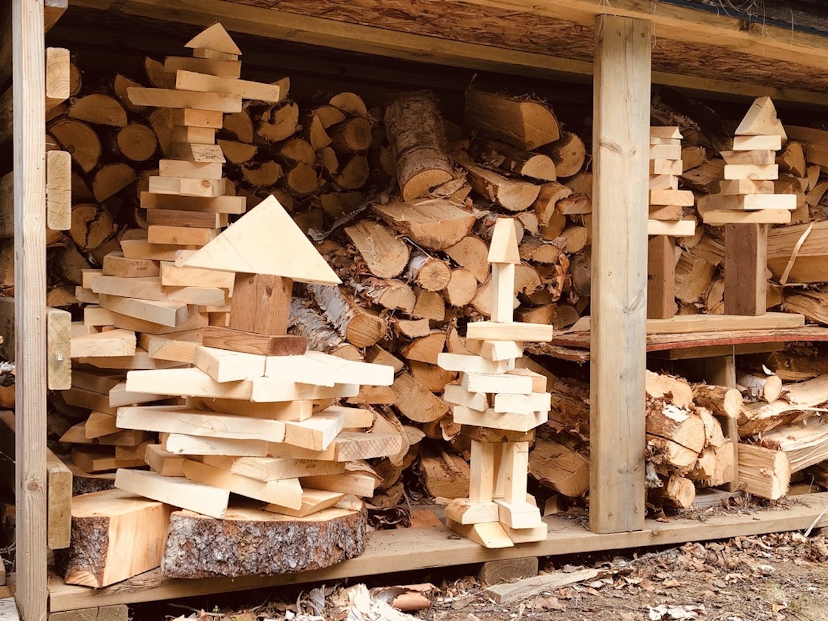 This is an image of a wood shed in which the wood cuttings have been stacked into various towers.